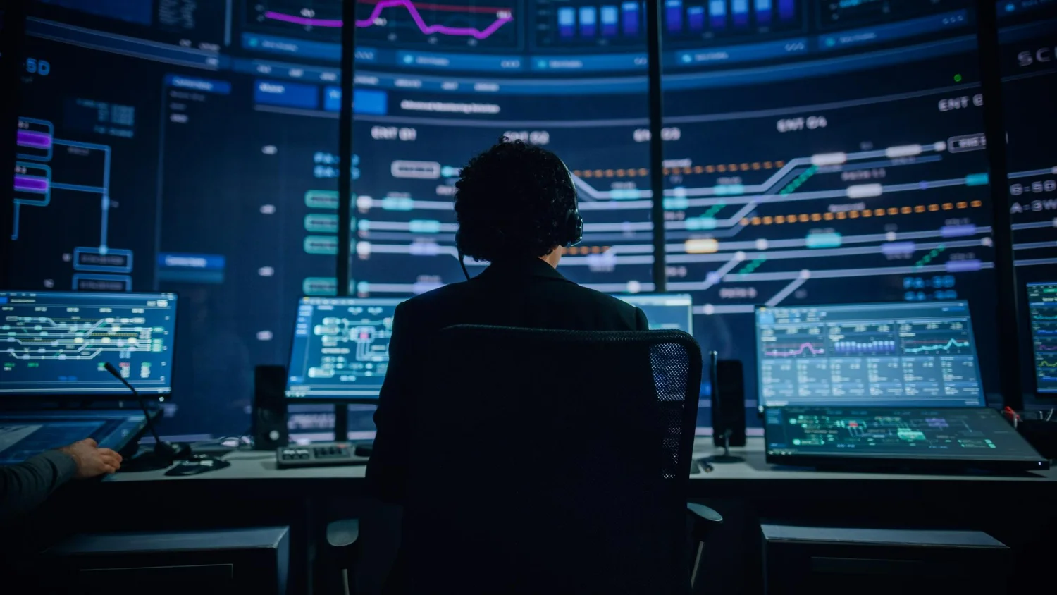 Imagem de um profissional de TI monitorando redes e infraestrutura em um NOC 24/7.
